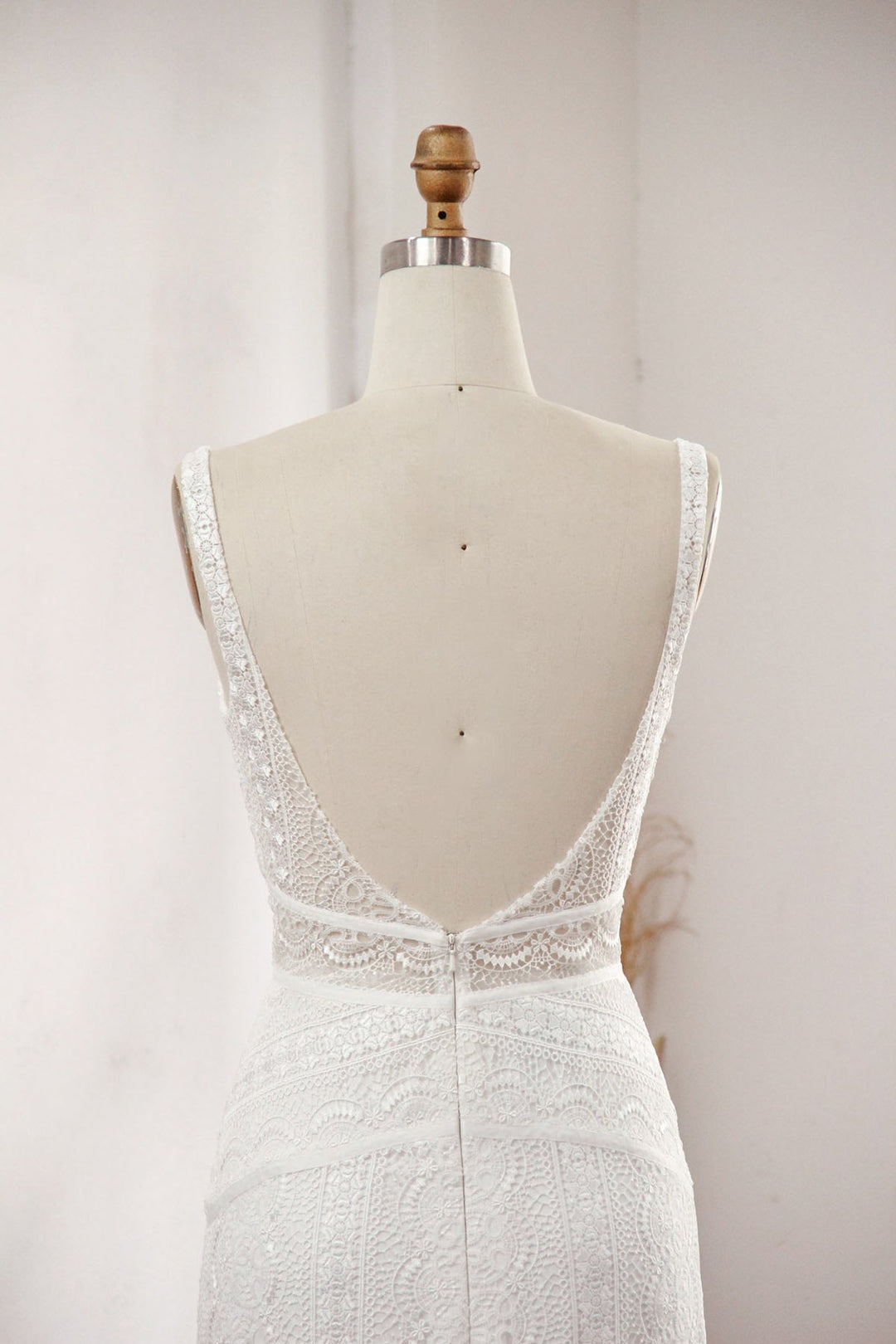 Modern column lace wedding dress close up of the back on a mannequin.