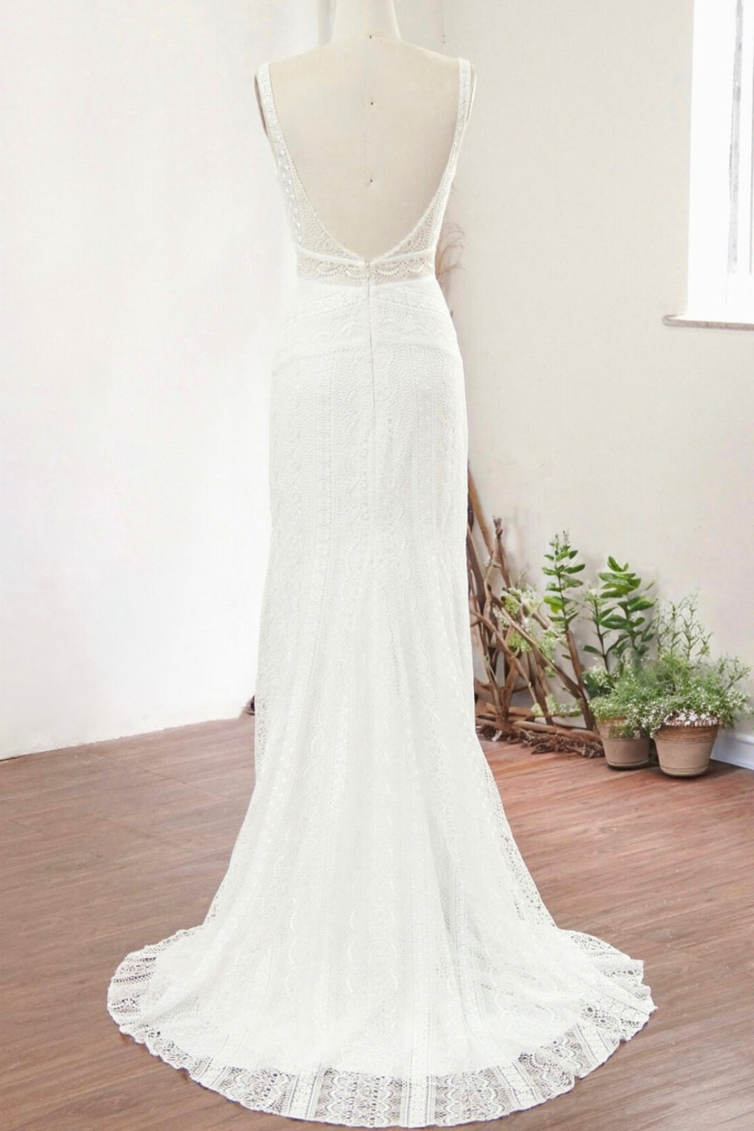 Modern column lace wedding dress with low back on a mannequin.