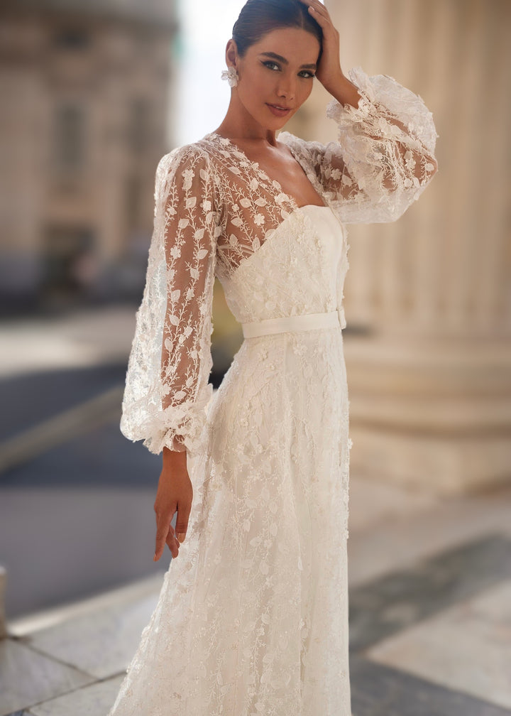 Woman in a strapless satin mermaid wedding dress with a sheer botanical robe with sleeves and a belt.