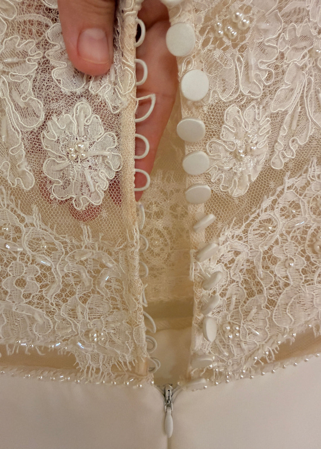 Back loop and button closure of sheer lace bodice and simple chiffon skirt wedding dress.